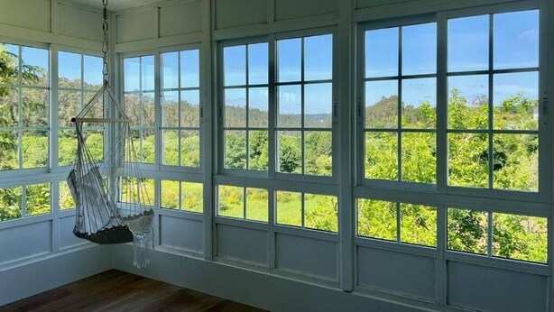 A room with large windows offering a view of greenery and hills. - Casa Santi - 10 minutes from Santiago (Santiago de Compostela)