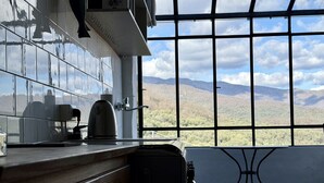 A kitchen with a view of mountains through a large window. - Relais Limone (Dolcedo)