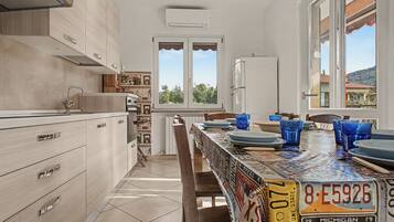 Una cucina moderna con zona pranzo, con isola centrale, frigorifero e finestra vista all'esterno.