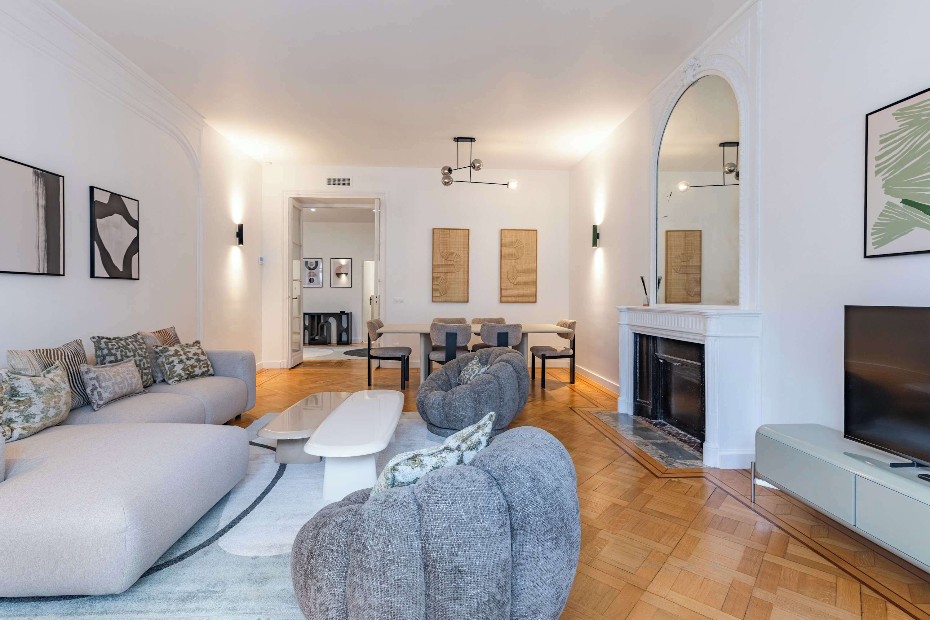 Un salon moderne avec un canapé, une table basse et une cheminée.