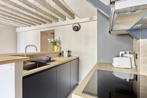A modern kitchen with a built-in dishwasher, a sink, and a toaster. - Marais — Confort moderne & charme parisien (Paris)