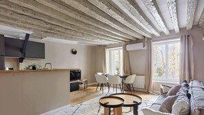 A modern living space with a kitchen, dining area, and seating area. - Marais — Confort moderne & charme parisien (Paris)