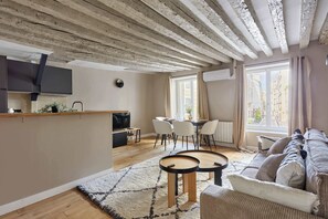 A modern living space with a kitchen, dining area, and seating area. - Marais — Confort moderne & charme parisien (Paris)