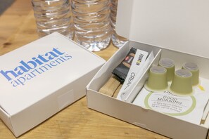 A white box labeled "Habitat Apartments" with a tea set and a wooden brush inside. - Verdi 11 - Habitat Apartments (Barcelona)