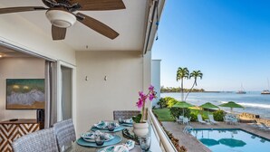 Ein Balkon mit Esstisch, Deckenventilator und Blick aufs Meer.