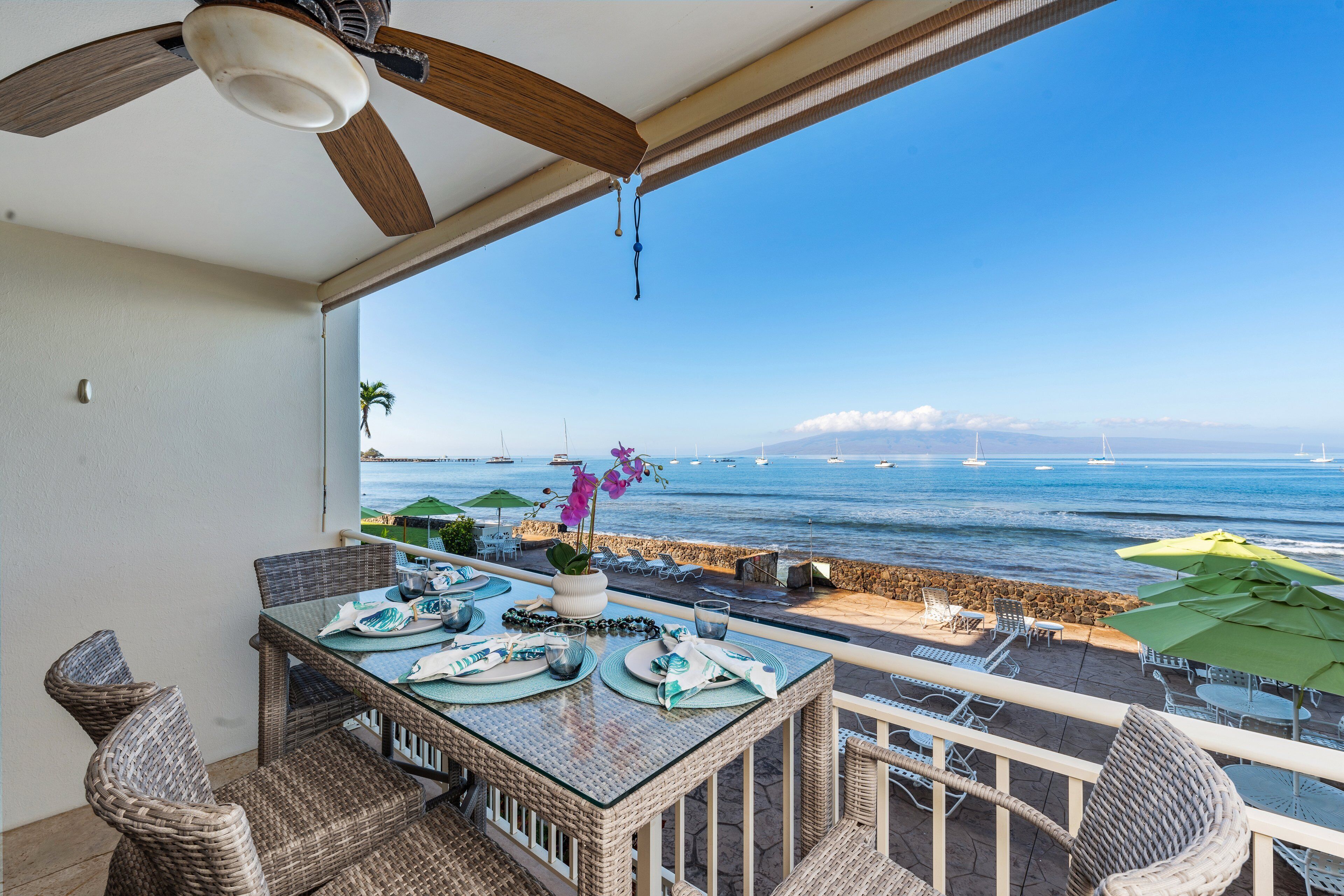 Dine by the sea with stunning views of sailboats, clear skies, and tropical scenery.