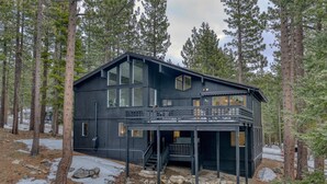 A modern cabin with large windows, a balcony, and a stone foundation. - Tahoe Retreat | Private Hot Tub & Scenic Views (Incline Village)