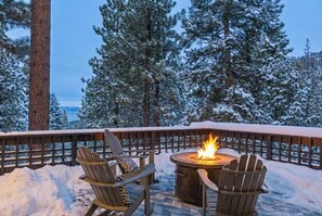 A snow-covered deck with two Adirondack chairs and a central fire pit. - Tahoe Retreat | Private Hot Tub & Scenic Views (Incline Village)