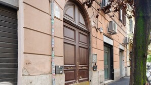 A building with a large brown door, a green door, and a sign above the green door. - Delightful Apartment near Vatican/Saint Peter's Area (Roma)