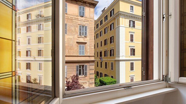 A window with a view of multi-story buildings, a window sill, and a door. - Delightful Apartment near Vatican/Saint Peter's Area (Roma)
