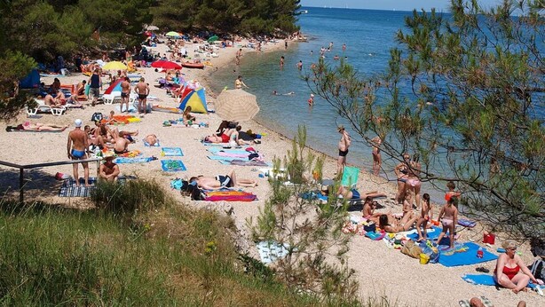 A crowded beach with people sunbathing and swimming, surrounded by trees and the sea. - Apartment with pool near Kanegra Beach (Valica)