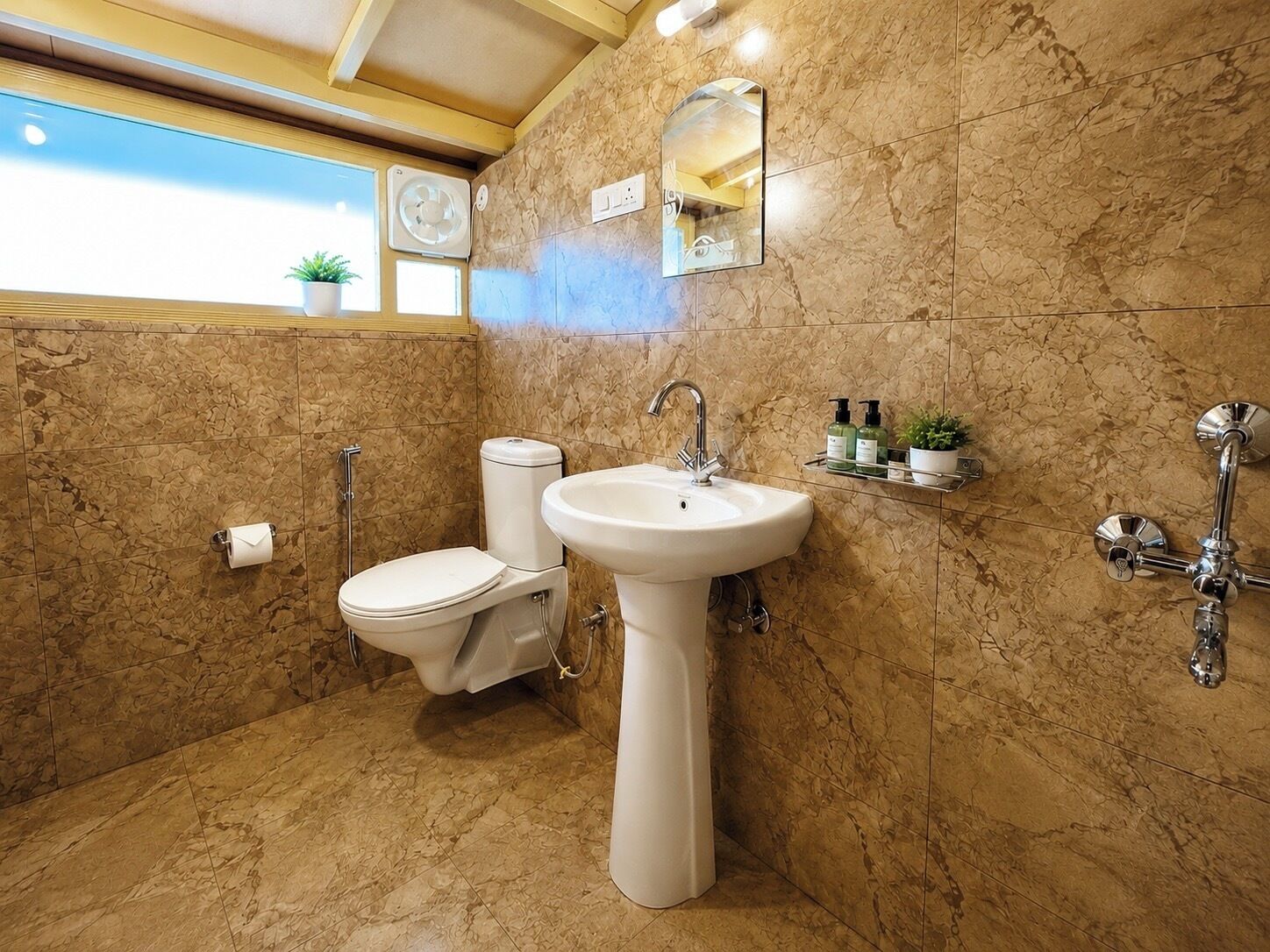 Une salle de bain avec des toilettes, un lavabo et une douche.