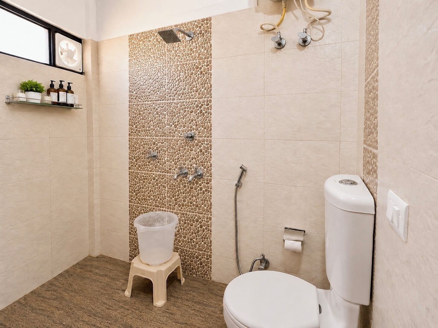 A bathroom with a shower, toilet, and a small stool.