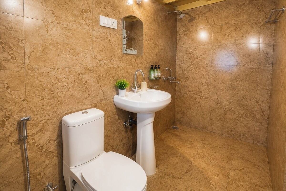 A bathroom with a toilet, sink, and shower.