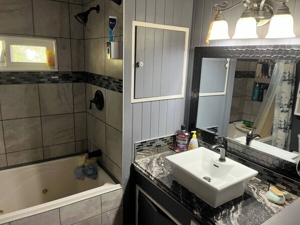 A modern bathroom with a bathtub, a sink, and a shower.