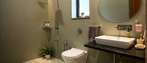 Un bagno moderno con un water autonomo, un lavabo con specchio e una cabina doccia.