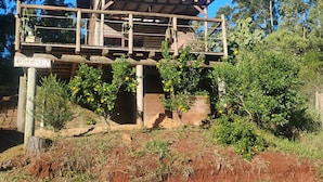 Une cabane rustique en rondins de bois, dotée d’une terrasse en bois et d’une enseigne indiquant qu’il s’agit d’une cabane en rondins.