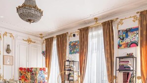 Uma sala de estar luxuosa com um sofá de couro, uma mesa de centro de vidro e uma estante de livros.