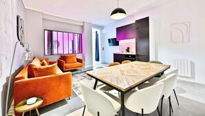 A modern living room with a dining area, bright lighting, and a view of the kitchen. - Loft moderne 2BR - Cœur de Paris A/C portable (Paris)
