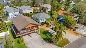 A residential area with a two-story house featuring a balcony, a driveway, and a lawn. - Joe`s Beach House | Walk to IRB | Family Friendly (Indian Rocks Beach)