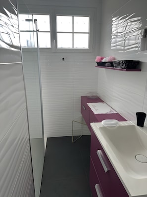 A modern bathroom with a glass shower enclosure, a white sink, and a vanity with a pink cabinet. - La Marée Hôtes Guesthouse – Poolside Retreat (Piriac-sur-Mer)