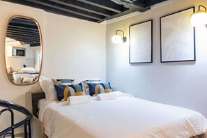 Ein Schlafzimmer mit einem Bett, einem Spiegel und zwei Wandleuchten.