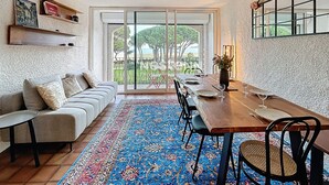 A dining area with a wooden table, chairs, and a blue patterned rug.