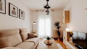 A modern living room with a sofa, coffee table, TV, and artwork on the wall. - Comfortable Apartment with Terrace in Logroño (Logroño)