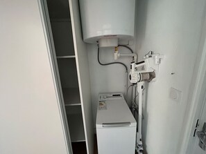 A compact utility room with a water heater, a control panel, and a water pump. - Air-conditioned apartment with parking, close to beach and shops (Argelès-sur-Mer)