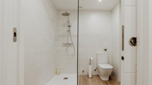 A modern bathroom with a shower, toilet, and a small sink. - Central Renovated Apartment with Wi-Fi in Logroño (Logroño)