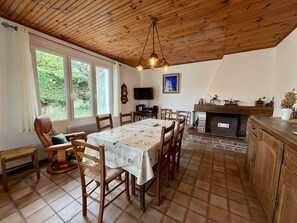 Ein Essbereich mit Tisch, Stühlen, Kamin und Fernseher.
