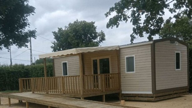 A small, single-story mobile home with a wooden deck and a covered porch. - Mobile Home ADA 28m², 4 pers, Terrace (Marcilly-sur-Vienne)