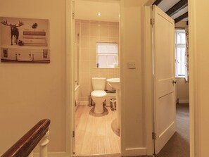 Une salle de bain avec des toilettes, un lavabo et une fenêtre.