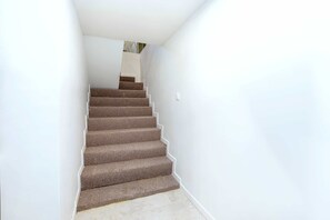 Eine Treppe mit Teppichstufen, die zu einer Zwischenebene führt.