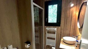 Une petite salle de bain comprenant des toilettes, un lavabo et une douche.