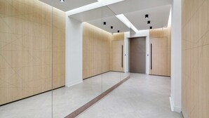A modern elevator with a minimalist design, a clean floor, and a geometric wall pattern. - Libere Paris Haussmann (Paris)