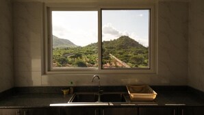 Eine Küche mit doppelter Spüle und Blick auf eine Berglandschaft durch ein Fenster.