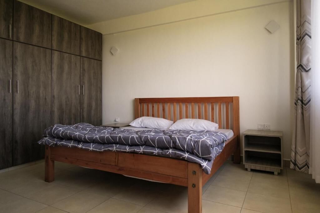 Un dormitorio con una cama de madera, una mesita de noche y un armario.