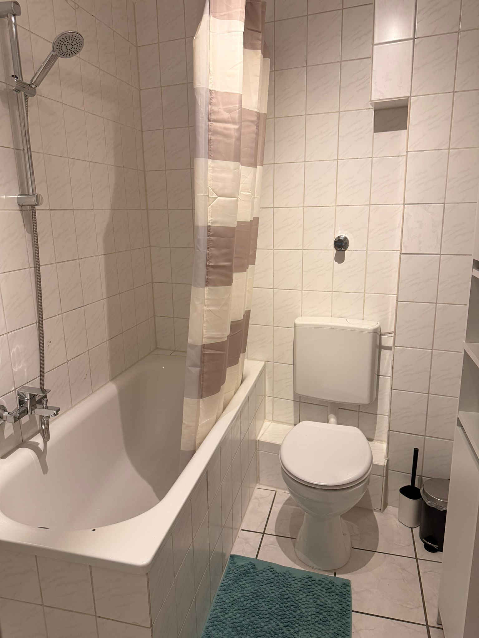 Een badkamer met bad, toilet en douche.
