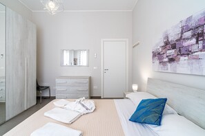 A hotel room with a bed, a wardrobe, a mirror, a door, and a wall art piece. - Villa 'Falaride' with Private Pool, Wi-Fi, and Air Conditioning (Avola)