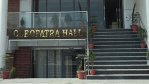 Entrada de un hotel con un letrero que dice "Hotel Elite Suites" y "Salón Cleopatra".