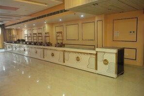 A long reception desk with decorative panels and a polished floor. - Hotel Elite Suites (Padrauna)