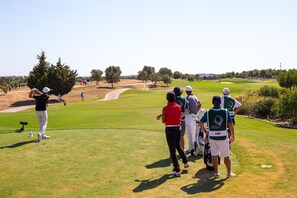A golf course with a clear path, trees, and a group of people standing on the grass. - Las Palmeiras Vilamoura (Vilamoura)