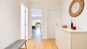 A hallway with a bench, a wicker basket, and a mirror on the wall. - Las Palmeiras Vilamoura (Vilamoura)