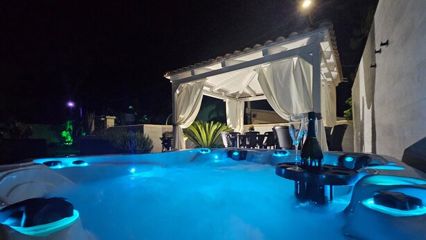 A hot tub area with a covered seating area, a bottle, and a glass. - Holiday Home 'Villa Anny Seafront' with Wi-Fi and Air Conditioning (Avola)