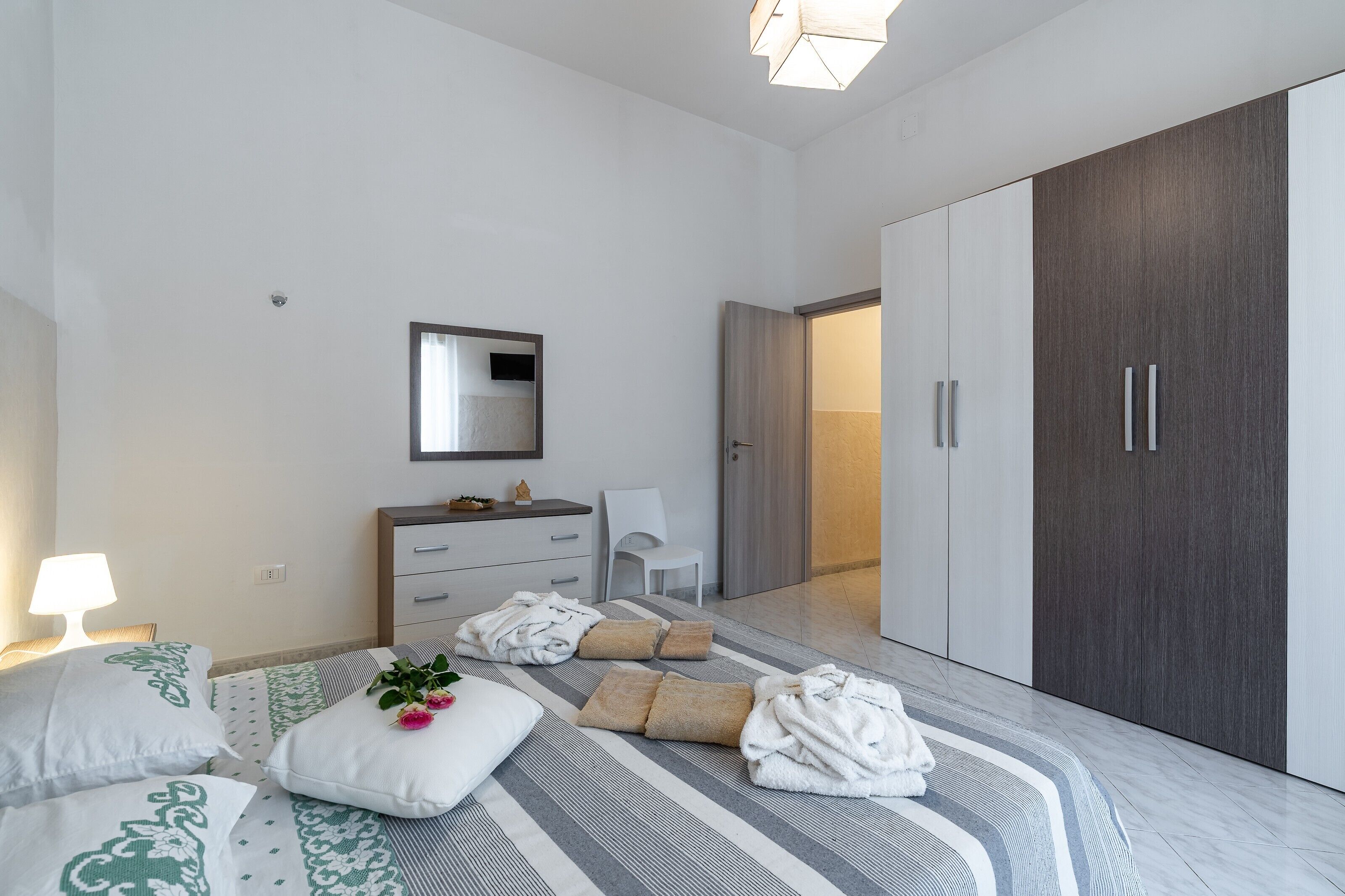 Ein modernes Schlafzimmer mit Bett, Nachttisch, Kommode und Kleiderschrank.