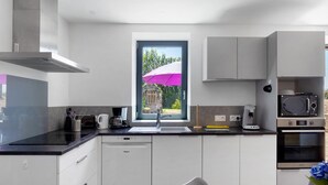 Una cucina moderna con lavastoviglie, forno a microonde e una finestra vista verde.