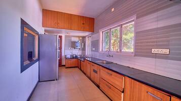 A modern kitchen with wooden cabinets, a black countertop, and a window providing natural light.