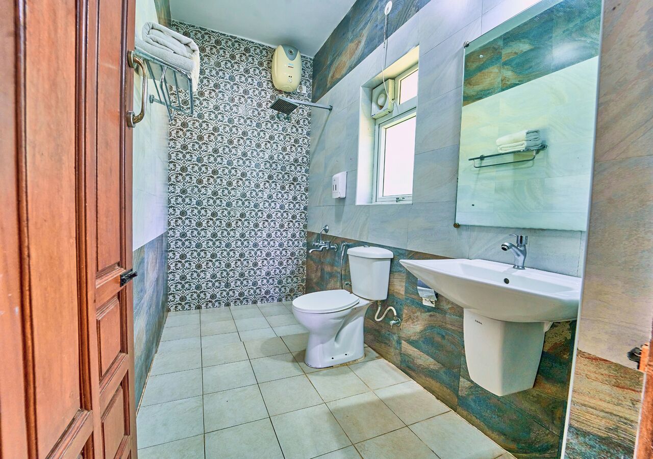 A bathroom with a toilet, sink, and shower.