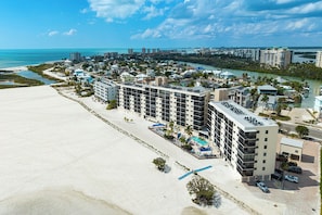 A coastal hotel with multiple floors, a beachside location, and a view of the ocean. - SUMMER DISCOUNT! Beachfront 2B/2B Vacation Condo Carlos Pointe 221. Amazing Views! EVERYTHING BRAND NEW! (Fort Myers Beach)